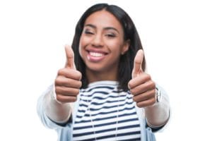 woman smiling and giving two thumbs up