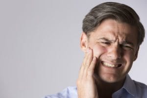 man grimacing in pain with toothache