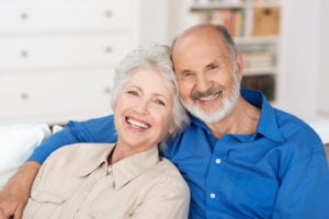 older couple sitting on couch and smiling