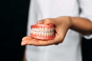 oral surgeon holding snap-in dentures