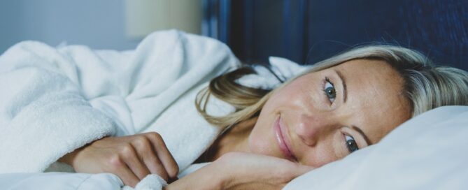 woman laying in bed smiling